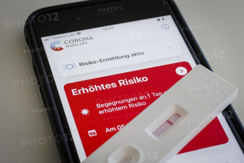 A negative rapid test is on a smartphone on which the Corona Warn app displays the words Increased Risk. Berlin