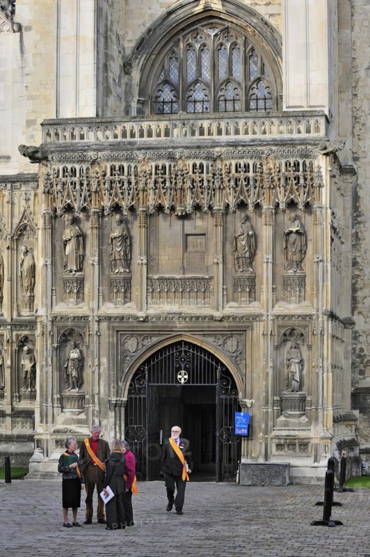 Tour guides wearing orange sashes leaving the Canterbury Cathedral in Canterbury
