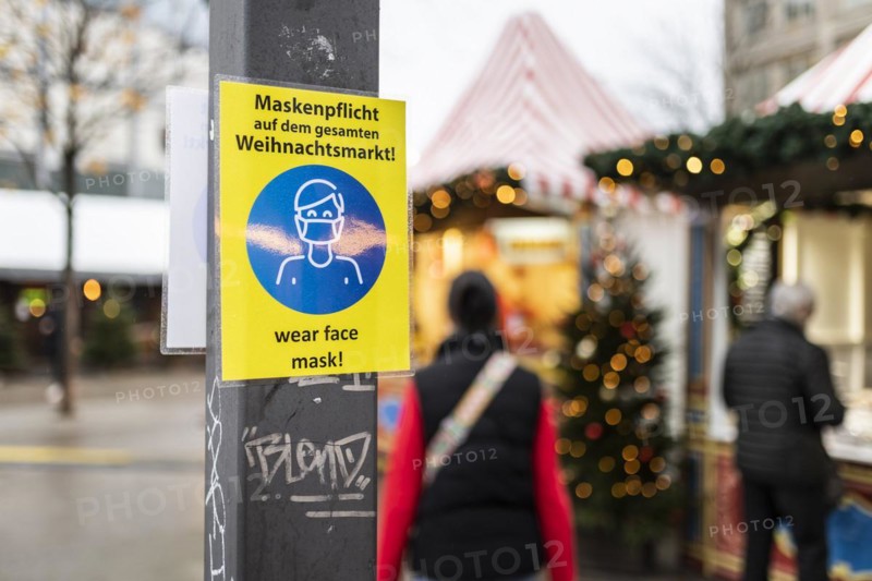 A sign indicating that masks are compulsory stands out at the Christmas market on Alexanderplatz in Berlin