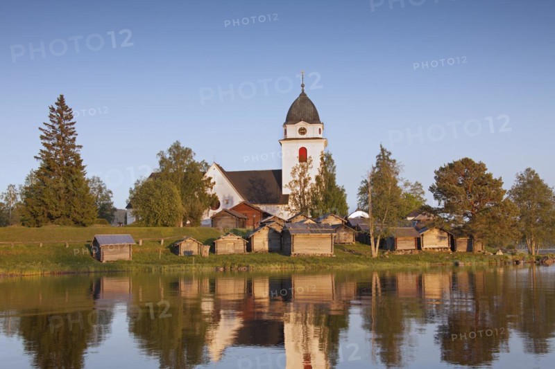The picturesque old Raettvik Church surrounded by horse stables along Lake Siljan