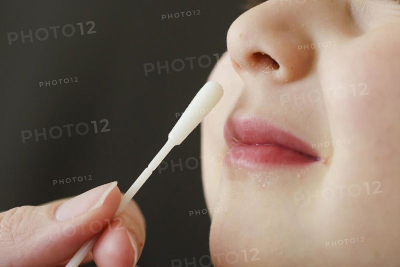 Symbolic photo on the subject of nasal testing for young children. A mother takes a swab from her child's nose. Berlin