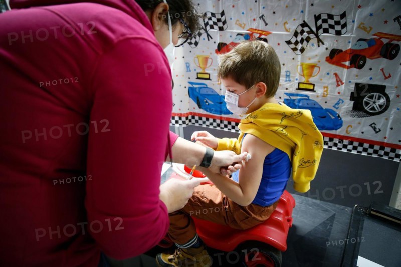 A boy is vaccinated by a doctor with the BioNTech Pfizer children's vaccine at a COVID-19 vaccination and testing centre at Autohaus Olsen in Iserlohn