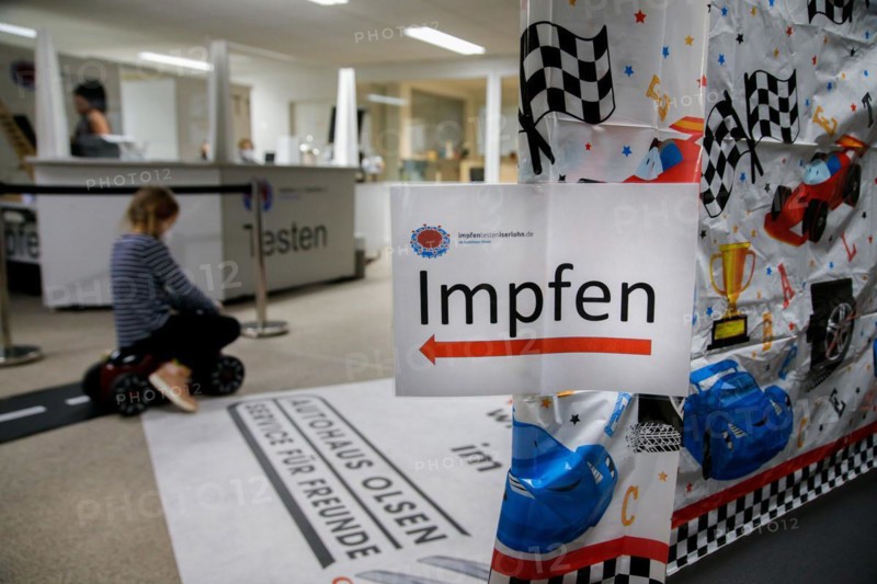A sign points the way to vaccination at a COVID-19 vaccination and testing centre at Autohaus Olsen in Iserlohn