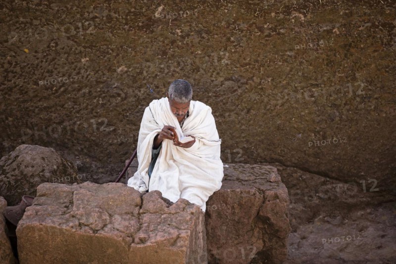 Man in white reading the bible at Biete Medhane Alem