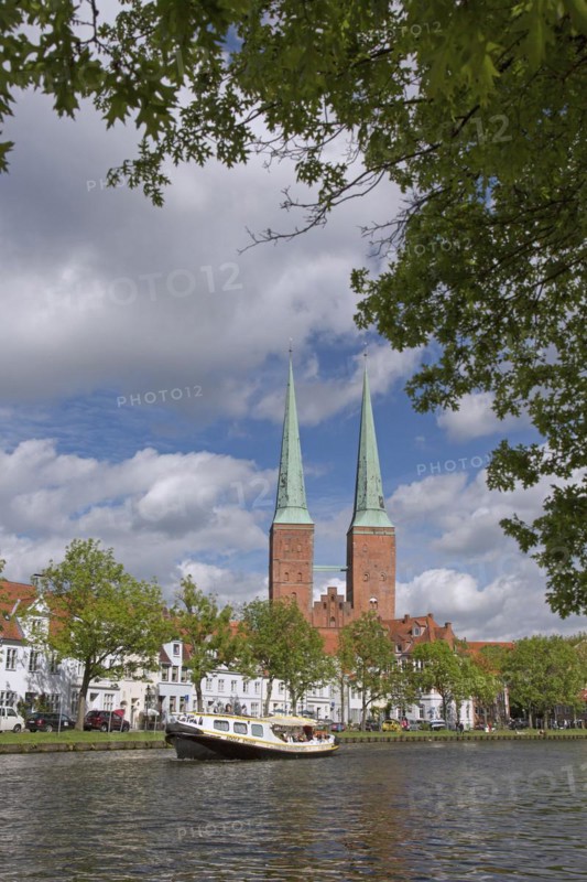 Tourist boat on the river Trave and the Luebeck Cathedral