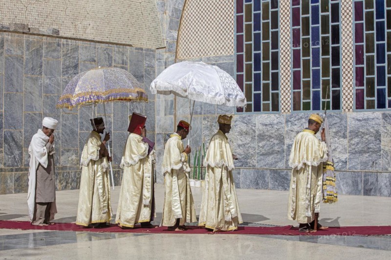 Orthodox priests with parasols during ceremony walking around the Church of Our Lady Mary of Zion