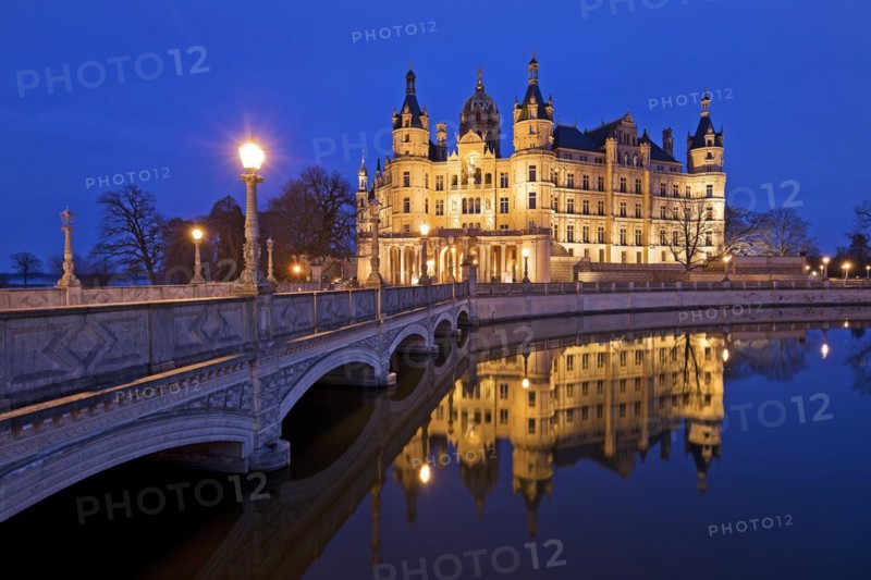 Illuminated Schwerin Castle with the castle bridge to the castle island in the evening