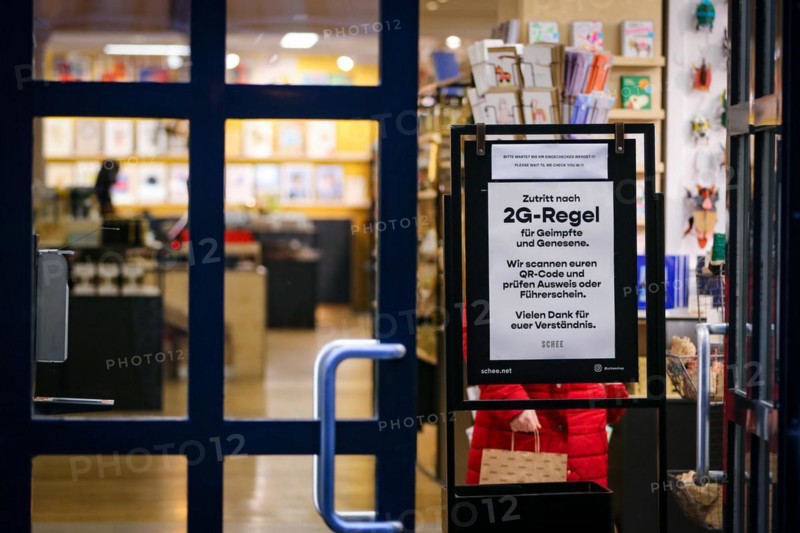 A sign at the entrance of a shop indicates the new retail access restrictions to combat the COVID-19 pandemic in Duesseldorf