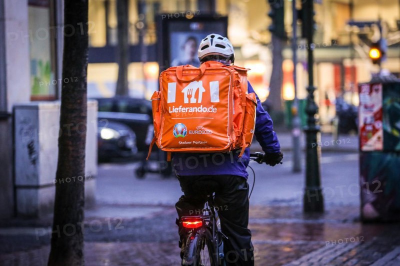 A driver of the delivery service Lieferando rides his bicycle through the old town of Duesseldorf