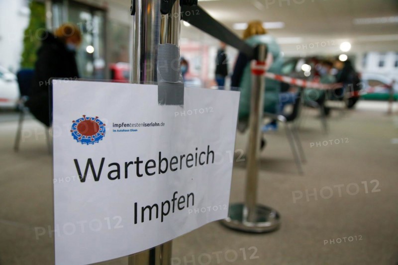 A sign indicates a waiting area for vaccination a COVID-19 vaccination and testing centre at Autohaus Olsen in Iserlohn
