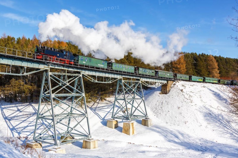 Steam train of the Fichtelbergbahn railway Steam locomotive on a bridge in winter in Oberwiesenthal