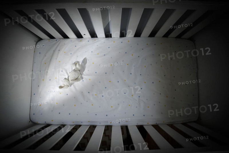Symbolic photo on the subject of child abuse. A stuffed animal lies in an empty cot. Berlin