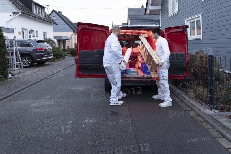 Subject: Master painter and apprentice loading a van with work materials
