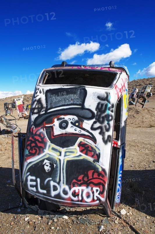 Cars sunk into the ground and sprayed with graffiti