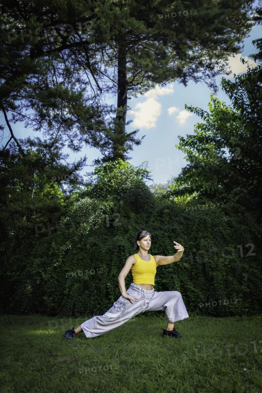 Woman practicing Tai Chi Quan in the park. Tai Chi is a physical and mental practice originating in China that combines smooth