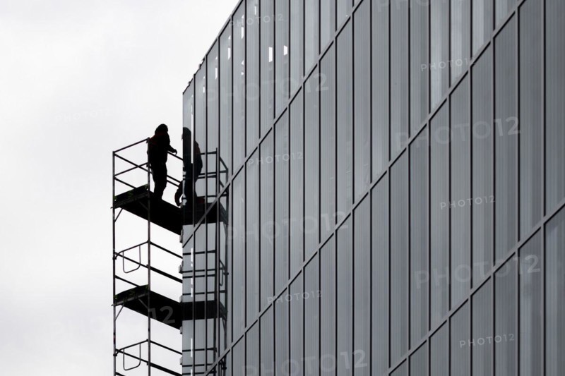 A construction worker is silhouetted on scaffolding in Berlin