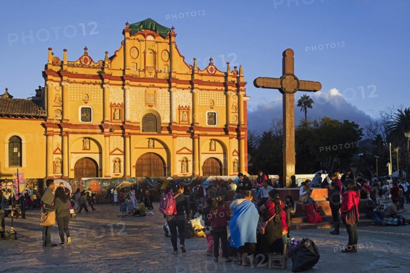 Mexicans at plaza with wooden cross and cathedral of the city San Cristobal de las Casas