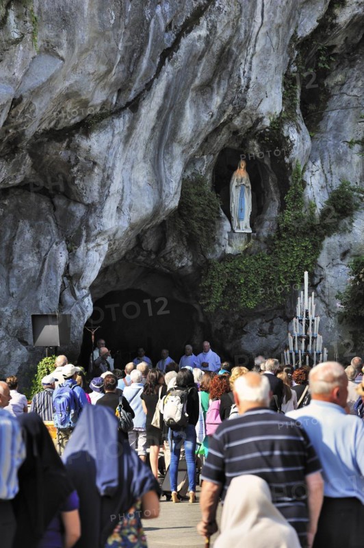 Pilgrims praying in front of the grotto at the Sanctuary of Our Lady of Lourdes