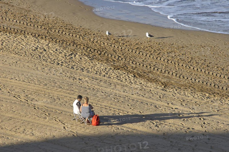 Two people sitting on folding chairs from behind