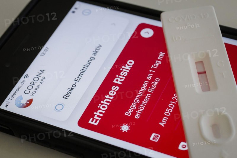A negative rapid test is on a smartphone on which the Corona Warn app displays the words Increased Risk. Berlin