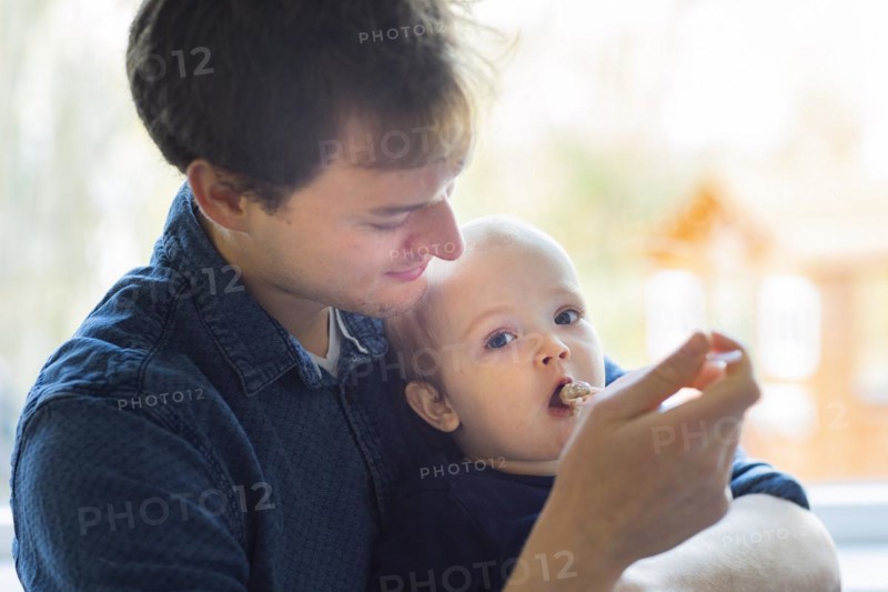 Subject: Father feeding his child at the age of nine months.