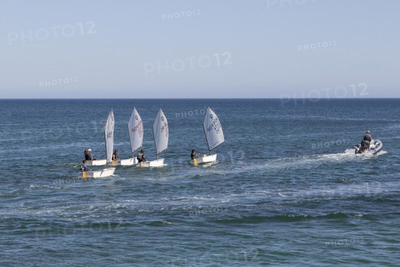 Optimist type dinghies of a sailing school sailing in the Atlantic Ocean off the coast of Lagos