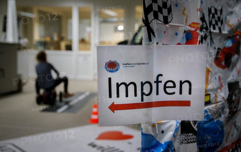 A sign points the way to vaccination at a COVID-19 vaccination and testing centre at Autohaus Olsen in Iserlohn