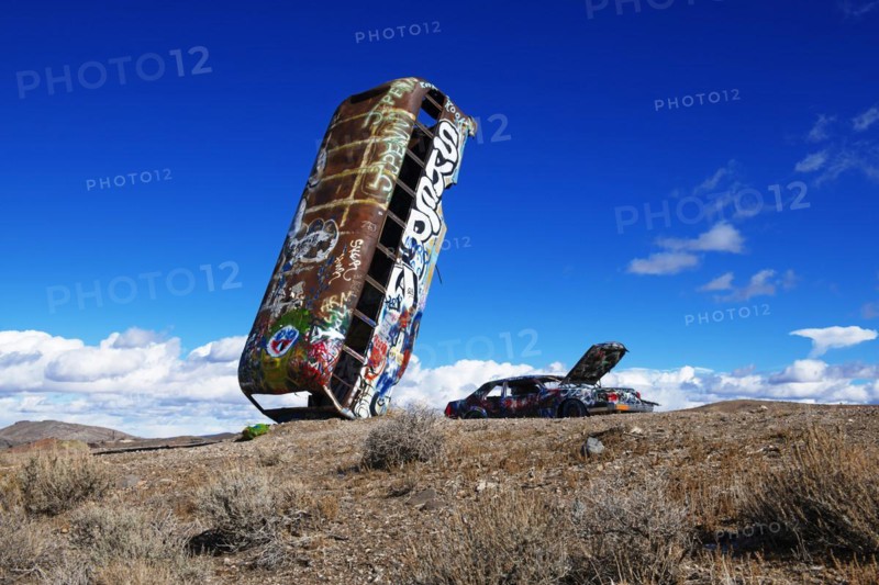 School bus and car sunk into the ground and sprayed with graffiti