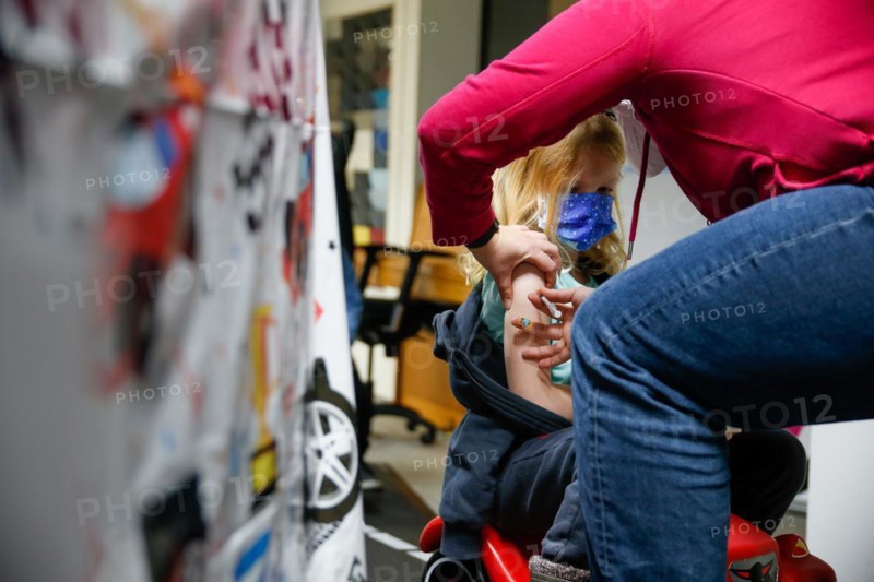 A girl is vaccinated by a doctor with the BioNTech Pfizer children's vaccine in a COVID-19 vaccination and testing centre at the Olsen car dealership in Iserlohn