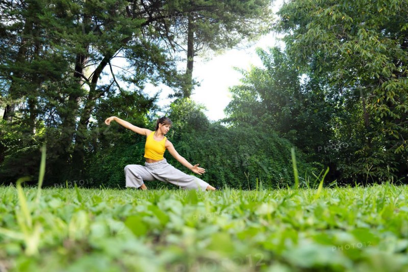 Woman practicing tai chi chuan outdoors. Practicing Tai Chi can help improve the body's flexibility