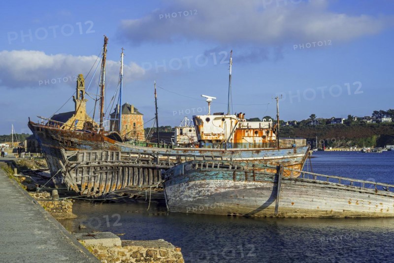 Tourists visiting wrecks of old wooden trawler fishing boats