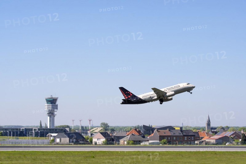 Control tower of Brussels Airport and the village Steenokkerzeel behind runway of Brussels Airlines while airplane is taking off