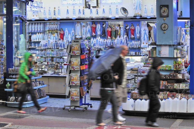 People buying religious souvenirs in souvenir shop near the Sanctuary of Our Lady of Lourdes