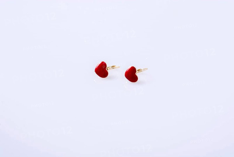Red color heart shaped earring on white background