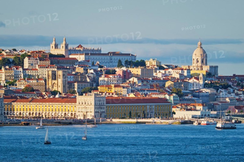 View of Lisbon Alfama district with National Pantheon and Monastery of St. Vincent over Tagus river from Almada with yachts tourist boats on sunset. Lisbon