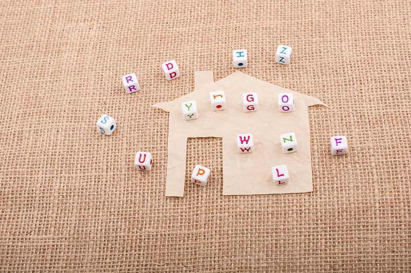 Letter cubes on house shape cut out of paper