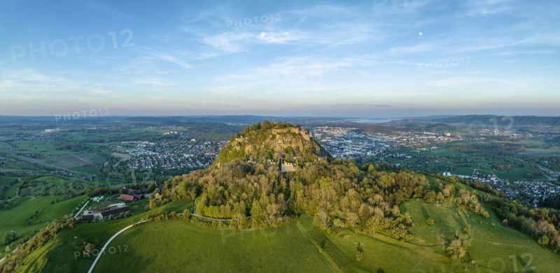 Aerial panorama of the volcanic cone Hohentwiel with the castle ruins illuminated by the evening sun