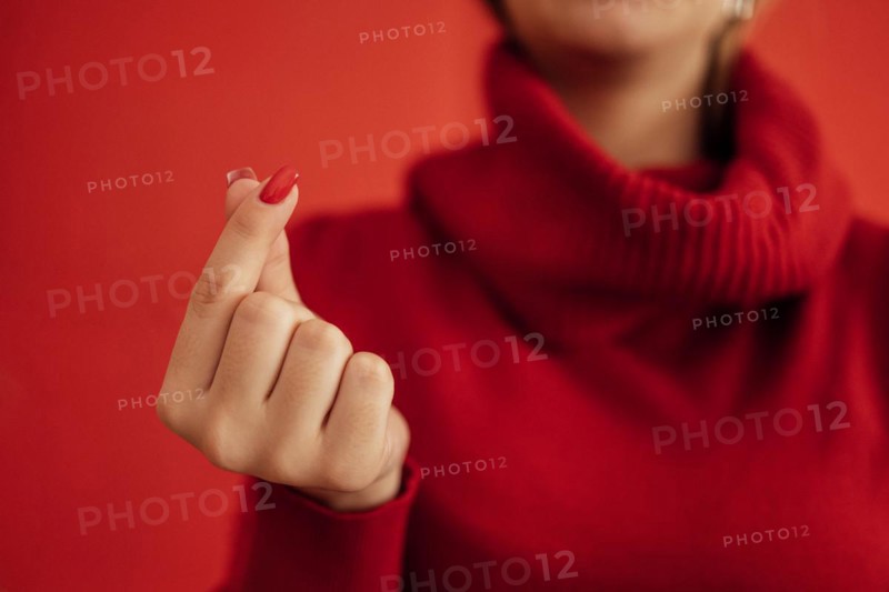The Korean symbol for love is obvious. A woman's hand covers a heart. Place for text. Happy Valentine's day