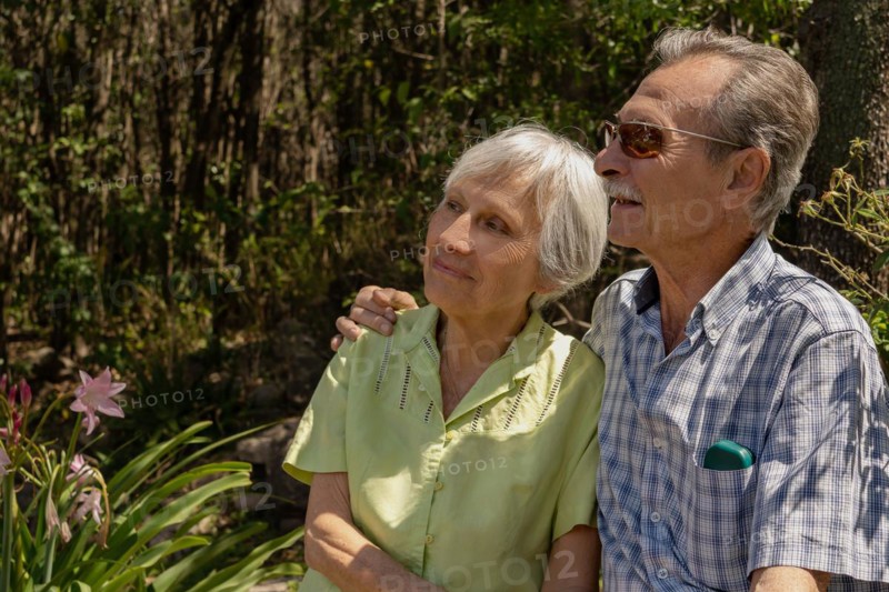 Elderly couple sitting hugging and enjoying time together outdoors. Concept health insurance