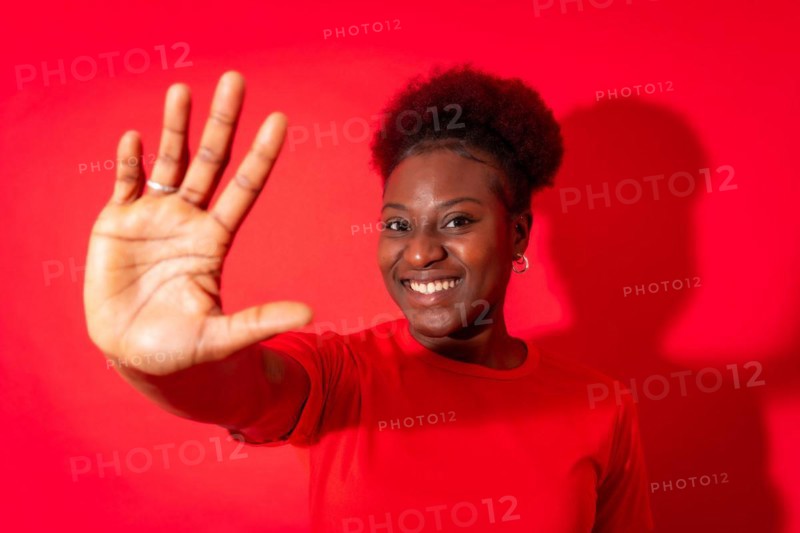 Young african american woman isolated on a red background with gesture stop from fingers