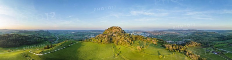 Aerial panorama of the volcanic cone Hohentwiel with the castle ruins illuminated by the evening sun