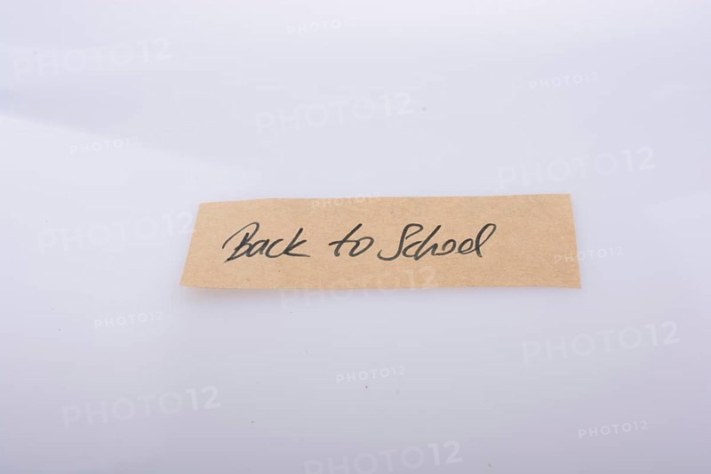 Back to school written on a note paper on white bakcground