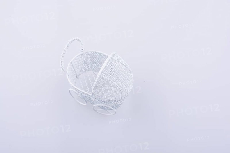 Toy baby carriage made of metal on white background