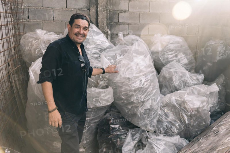 Man smiling and looking at camera showing his recycling work