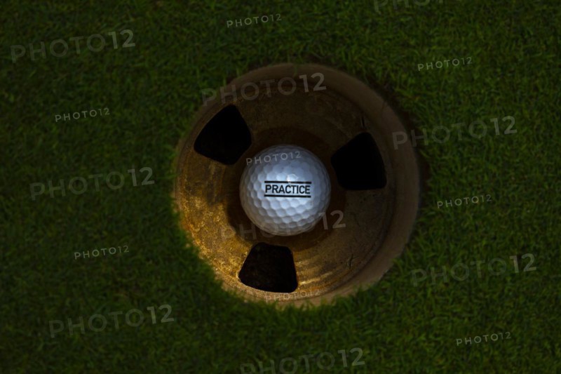 Golf Ball in the Hole on Putting Green with Text Practice in Switzerland