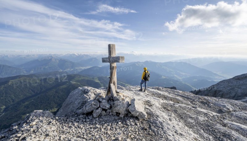 Mountaineer at a secondary peak of the Hochkoenig with summit cross