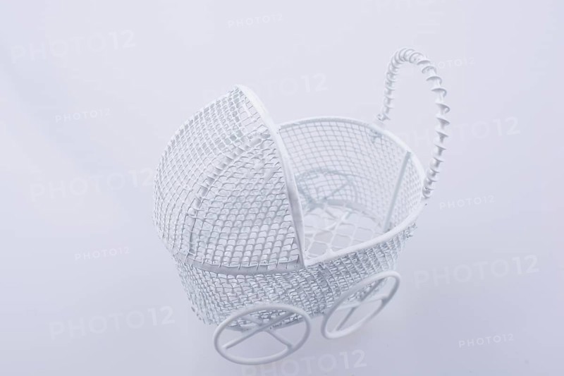 Toy baby carriage made of metal on white background