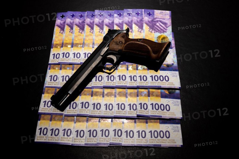 Elegant Semiautomatic 9mm Handgun with Swiss Helvetia Symbol Leaning on Swiss Franc 1000 Banknote in Switzerland