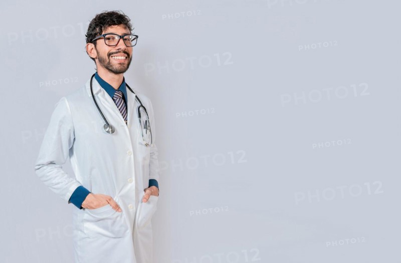 Portrait of happy doctor with hands in pockets isolated. Happy latin doctor with copy space isolated