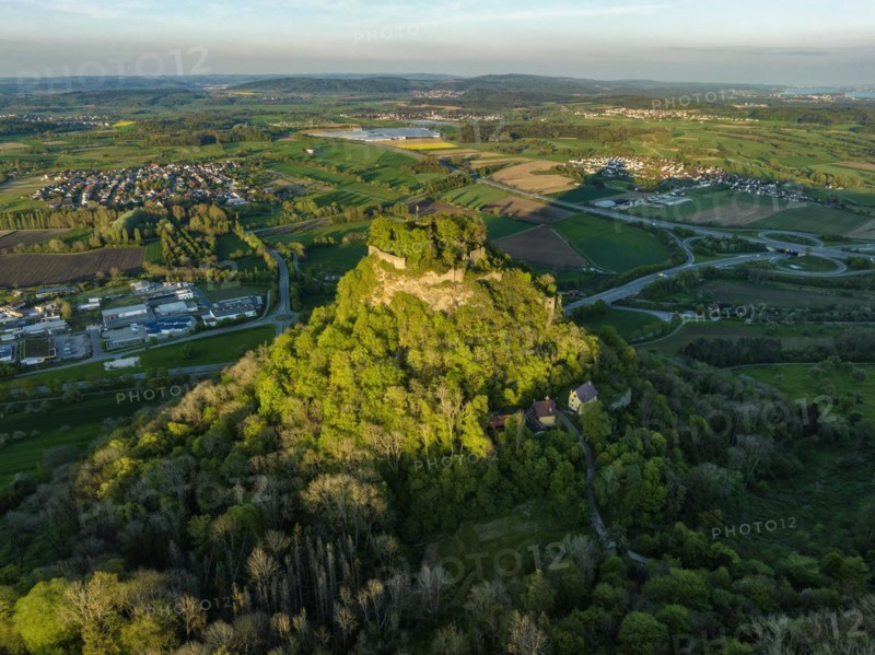 Aerial view of the Hegau volcano and the Hohenkraehen castle ruins illuminated by the evening sun